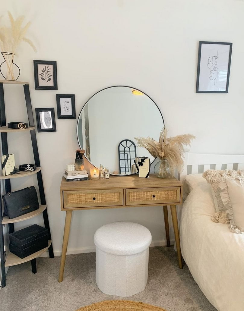 Rattan dressing table next to a bed as a nightstand with large mirror on top
