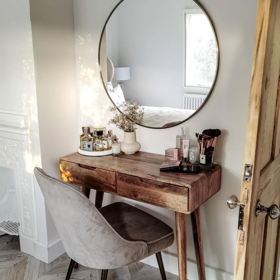 Wooden dressing table with a round mirror on the wall