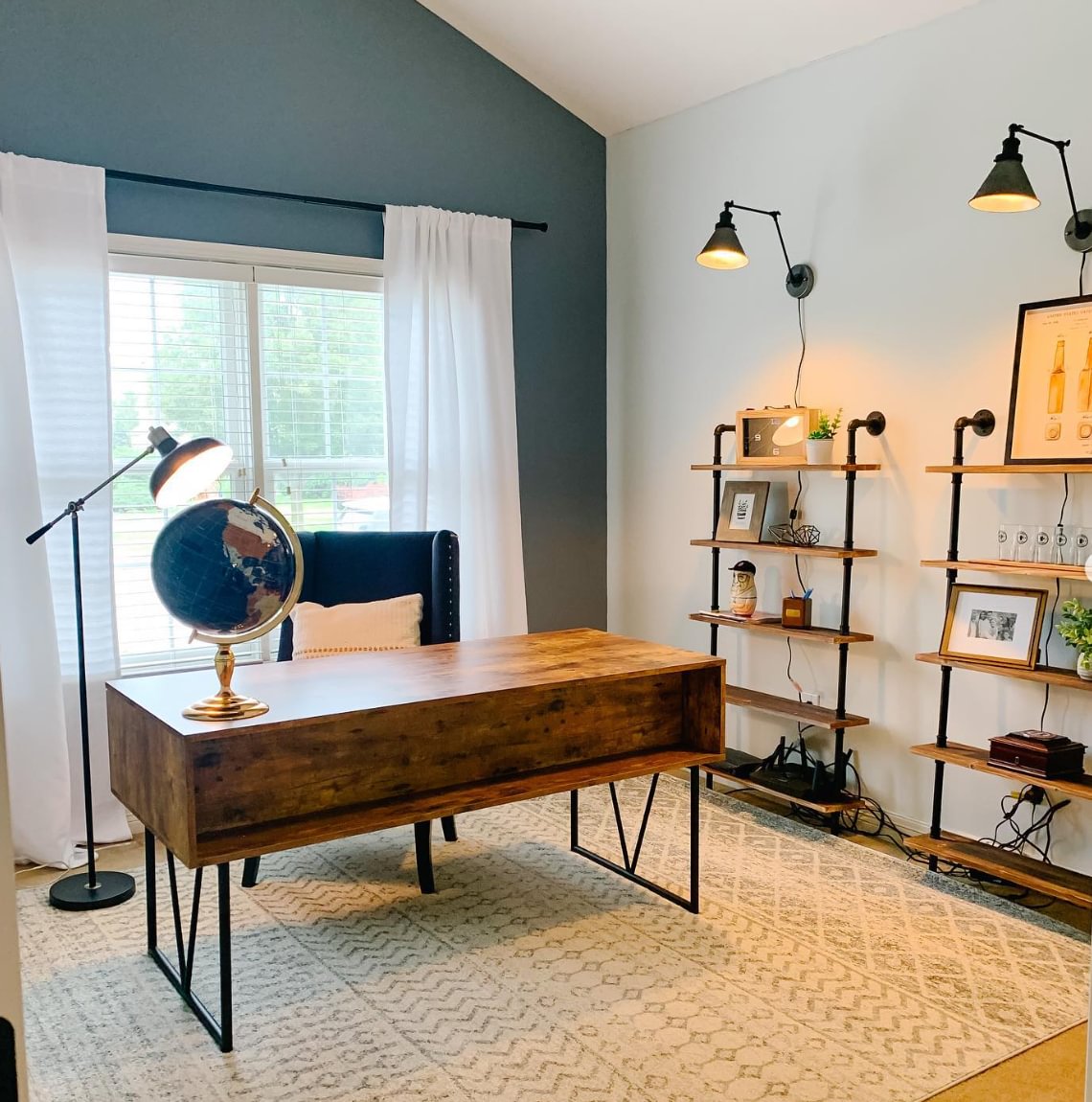 A home office with a wooden desk, rug, and industrial shelving
