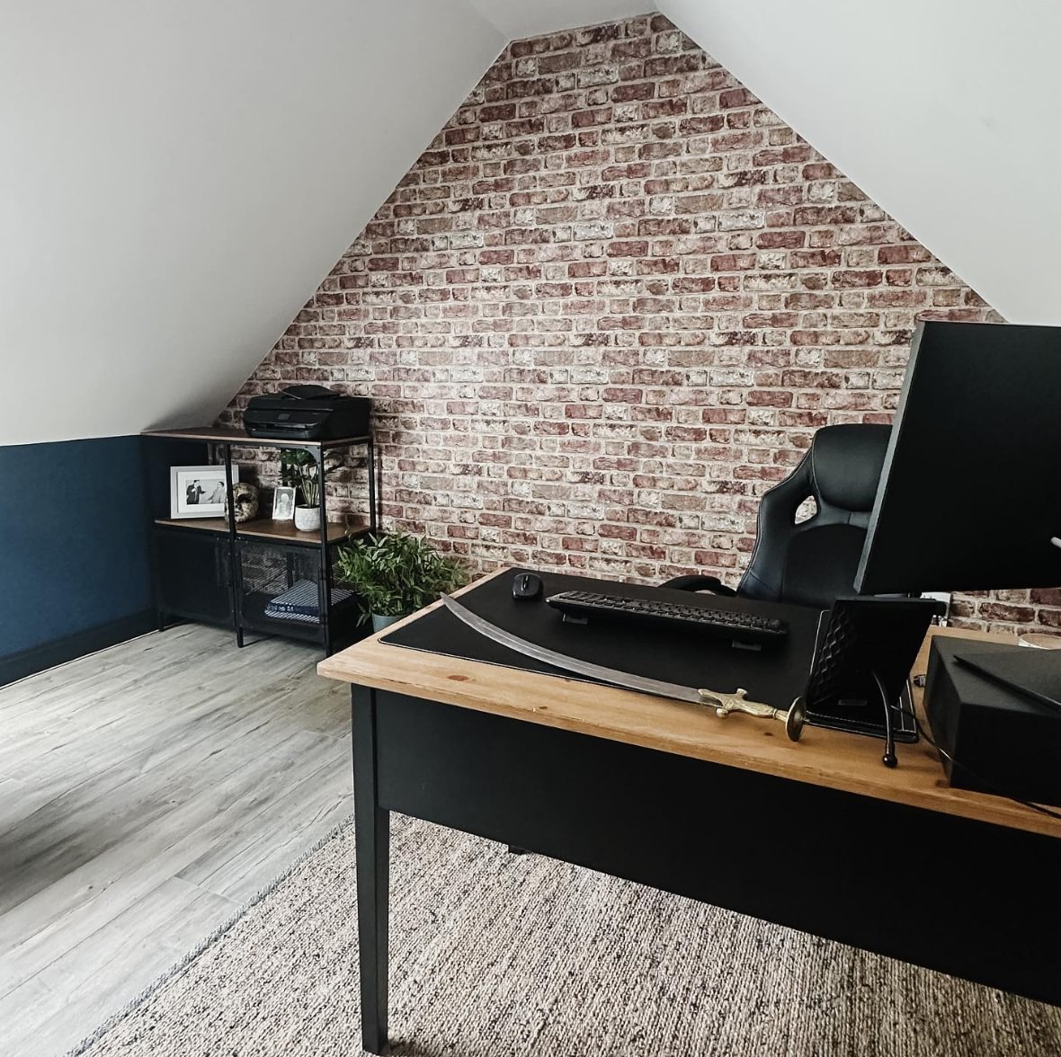 A home office with a brick feature wall and desk