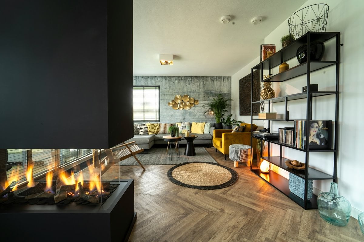 A living room with black shelving, wooden floor and a black fireplace in a wall