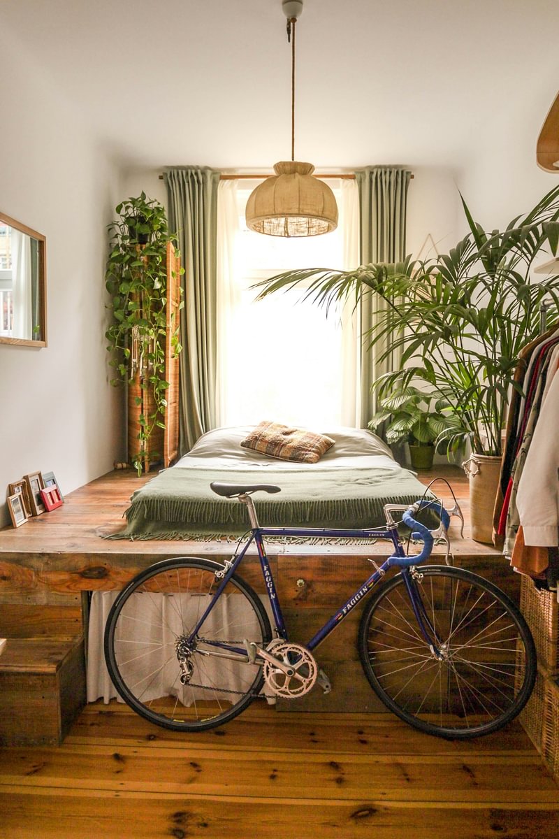 A bedroom with a raised bed and bicycle