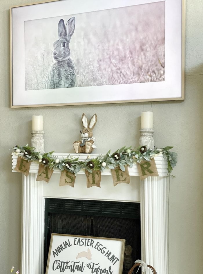 sage green wall with bunny art on wall and easter banner on fireplace
