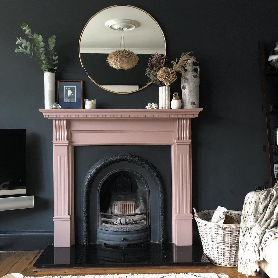 Black interior wall with dusky pink painted victorian style fireplace