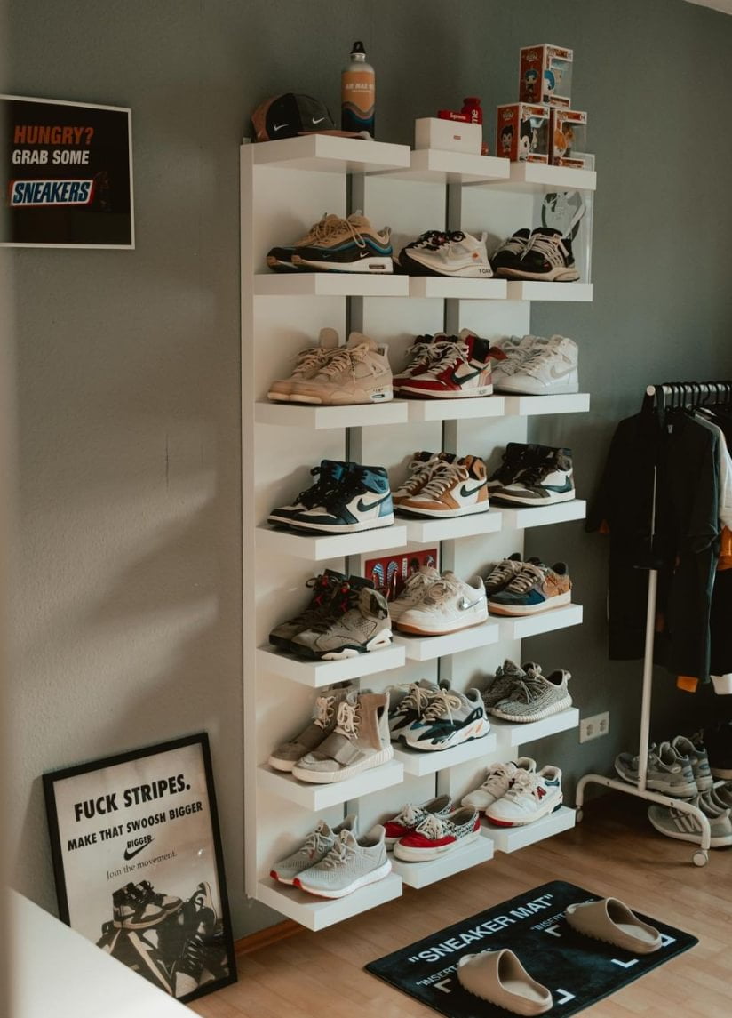 A shelving unit with sneakers on next to a clothes rail